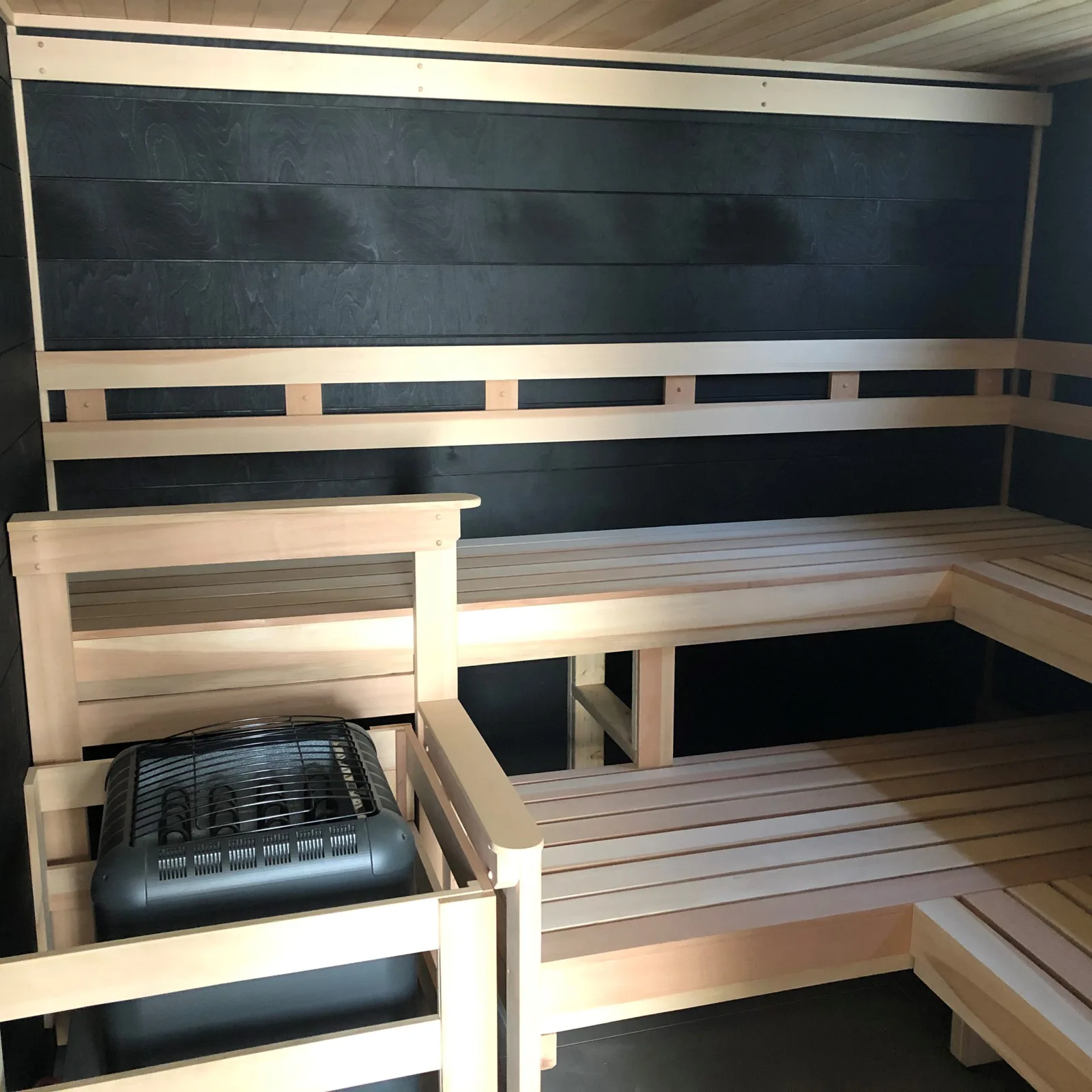 Richman: Black tikka wood walls contrast with Western red cedar across the ceiling, benches, and trim.